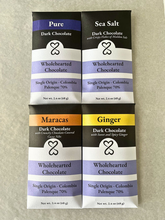 Four packages of Wholehearted Chocolate dark chocolate bars on a beige background