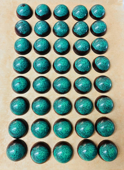 dark chocolate dome-shaped truffles with green design