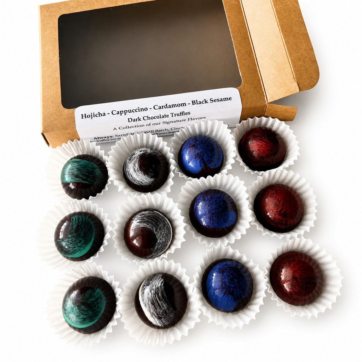 Assorted dark chocolate bonbons in white paper cups near a kraft paper box on a white surface.