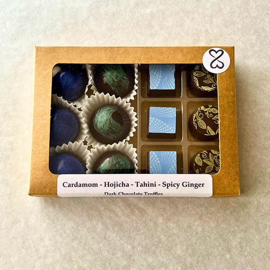 Box of dark chocolate bonbons with a label on a light background