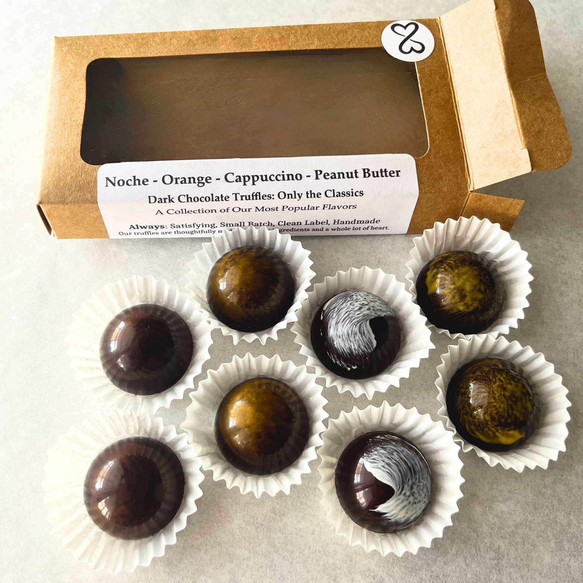 Dark chocolate truffles in white paper cups with a kraft paper box labeled "only the classics"