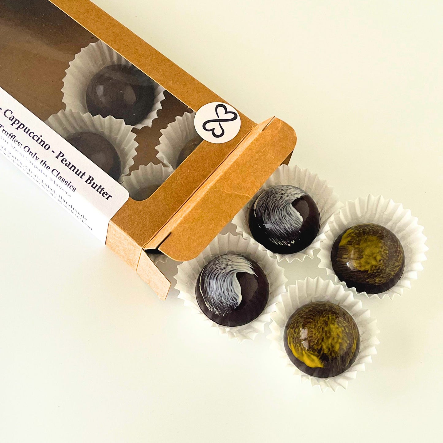 open box of colorful chocolate truffles. four outside the box and four still inside