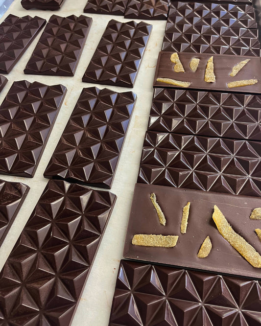 Chocolate bars with geometric pyramidal texture, topped with crystallized ginger slices