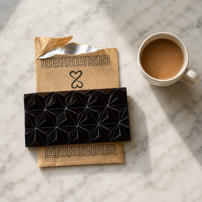 Pure Palenque 70% chocolate bar and package with a cup of coffee on marble
