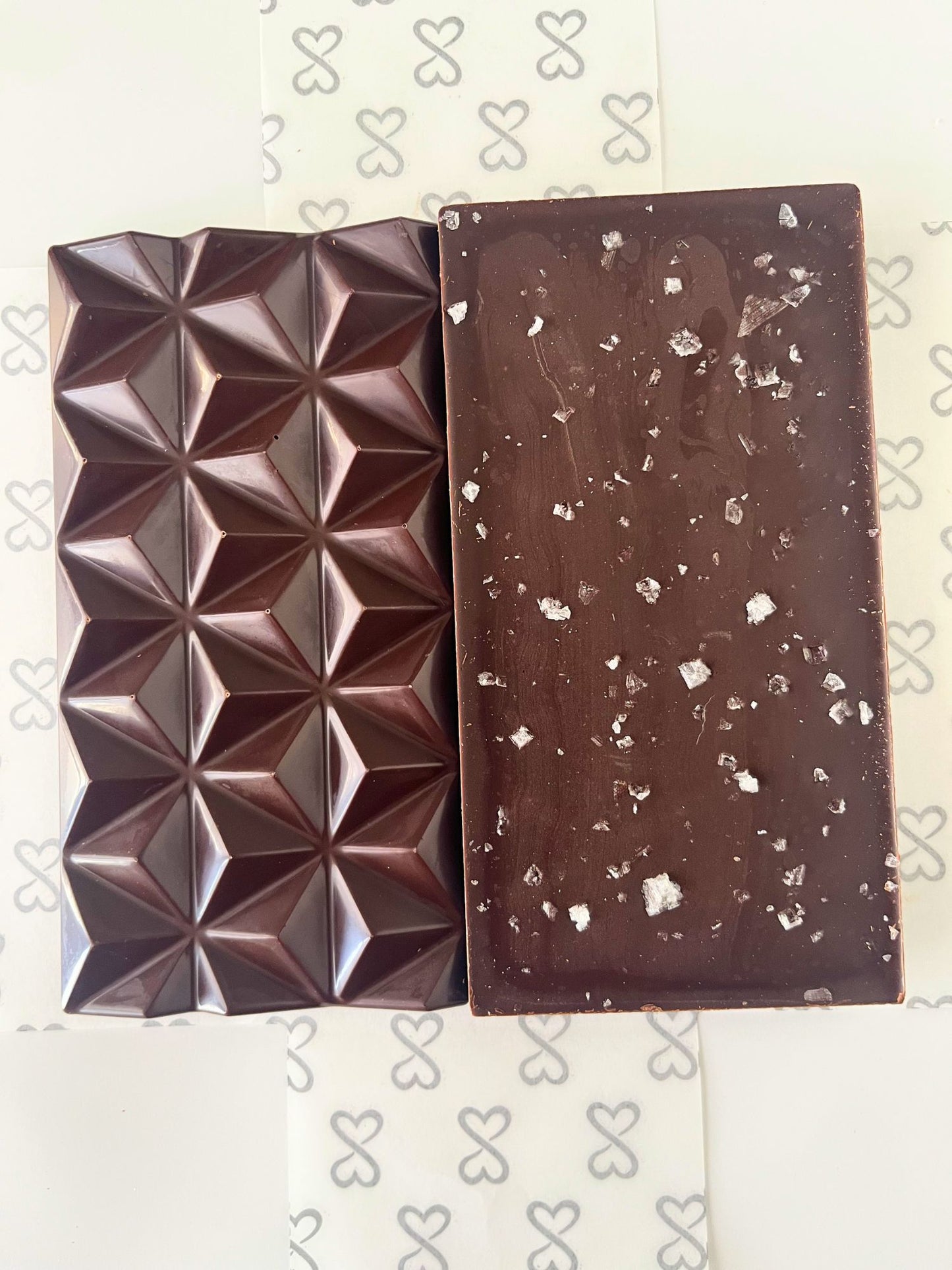 front and back of dark chocolate bar topped with flaky sea salt